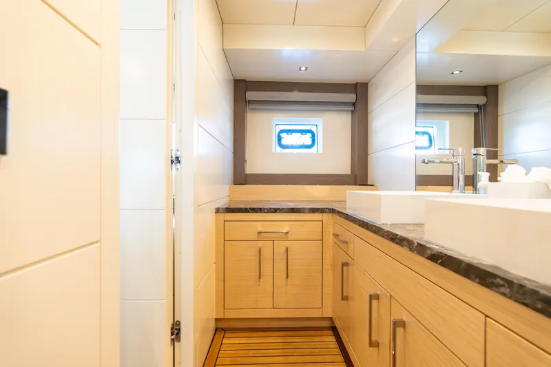 Amor Fati Yacht Photos Pics Luxurious bathroom interior on 2019 Sirena 64 yacht, featuring modern fixtures and wooden cabinetry.