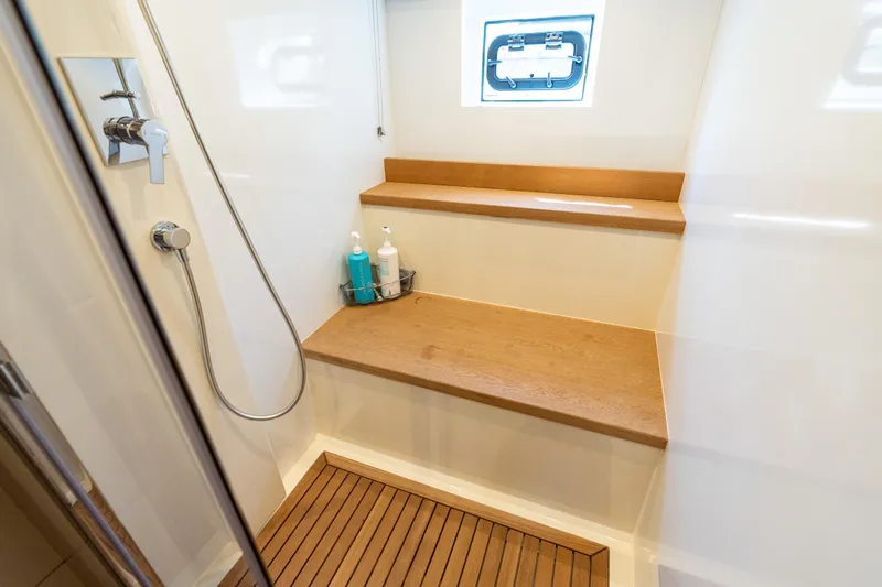 Amor Fati Yacht Photos Pics Shower area in 2019 Sirena 64 yacht with wooden bench and modern fixtures.