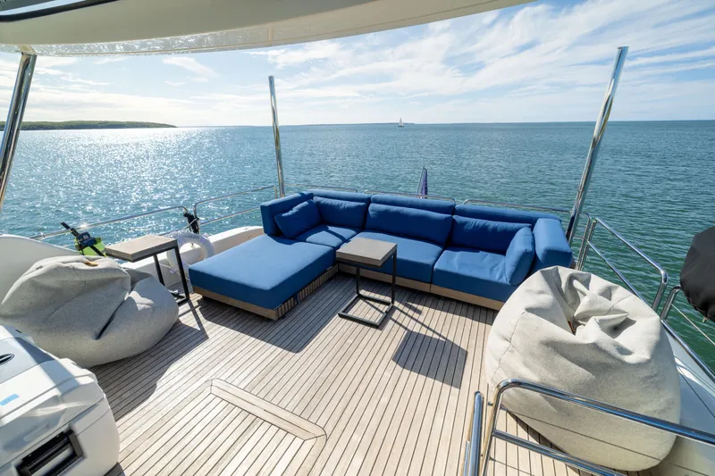 Amor Fati Yacht Photos Pics Luxurious deck of 2019 Sirena 64 yacht with blue seating and ocean view.