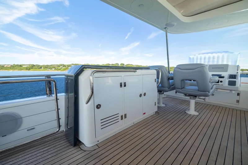 Amor Fati Yacht Photos Pics Luxurious 2019 Sirena 64 yacht deck with seating and navigation equipment, overlooking serene waters.