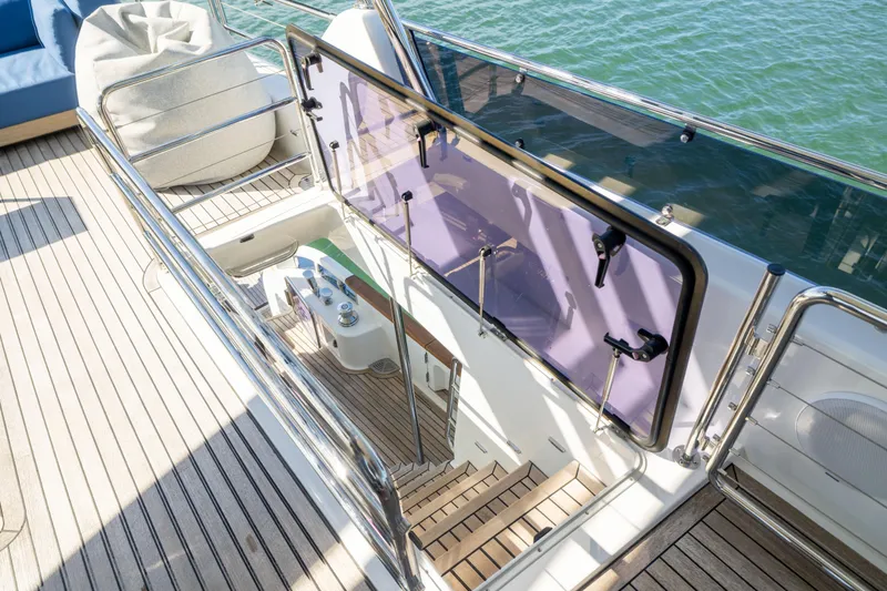 Amor Fati Yacht Photos Pics Staircase on 2019 Sirena 64 yacht with wooden deck and glass railing.