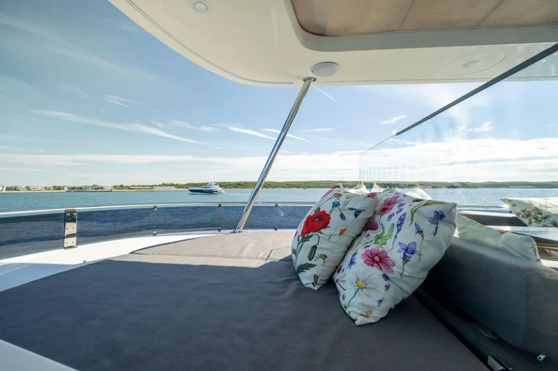 Amor Fati Yacht Photos Pics Luxurious 2019 Sirena 64 yacht deck with floral cushions, overlooking serene ocean view.