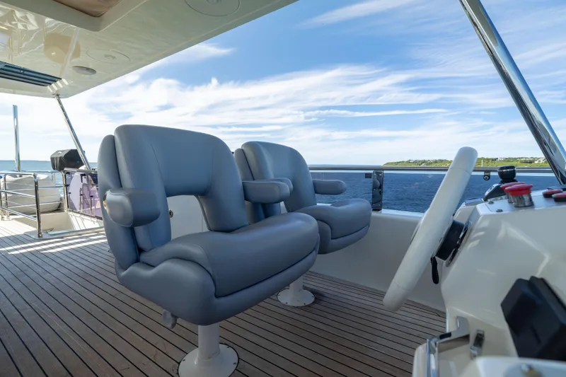 Amor Fati Yacht Photos Pics Luxury yacht Sirena 64 helm with plush seating, ocean view, and modern controls.