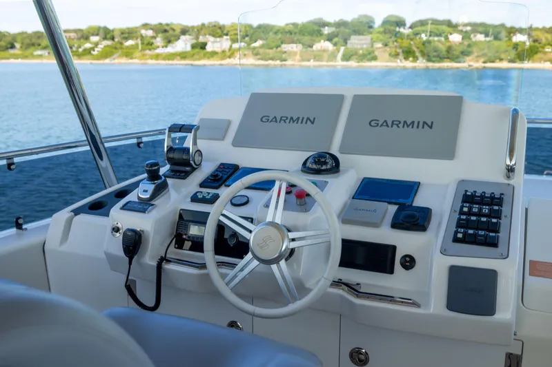Amor Fati Yacht Photos Pics Helm of 2019 Sirena 64 yacht with Garmin navigation systems, overlooking serene waters.
