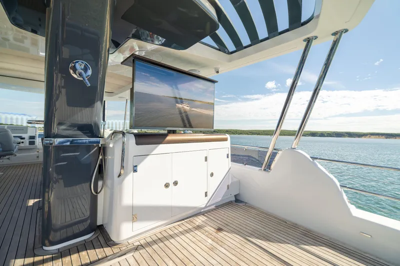 Amor Fati Yacht Photos Pics Luxurious 2019 Sirena 64 yacht deck with TV, overlooking serene ocean view.