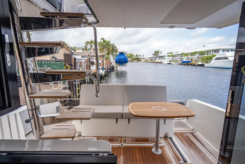  Yacht Photos Pics 2021 Skamander Monaco yacht deck with seating, table, and spiral staircase by a marina.