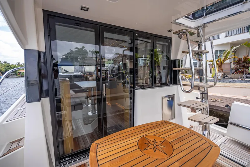  Yacht Photos Pics 2021 Skamander Monaco yacht interior with wooden table and spiral staircase.