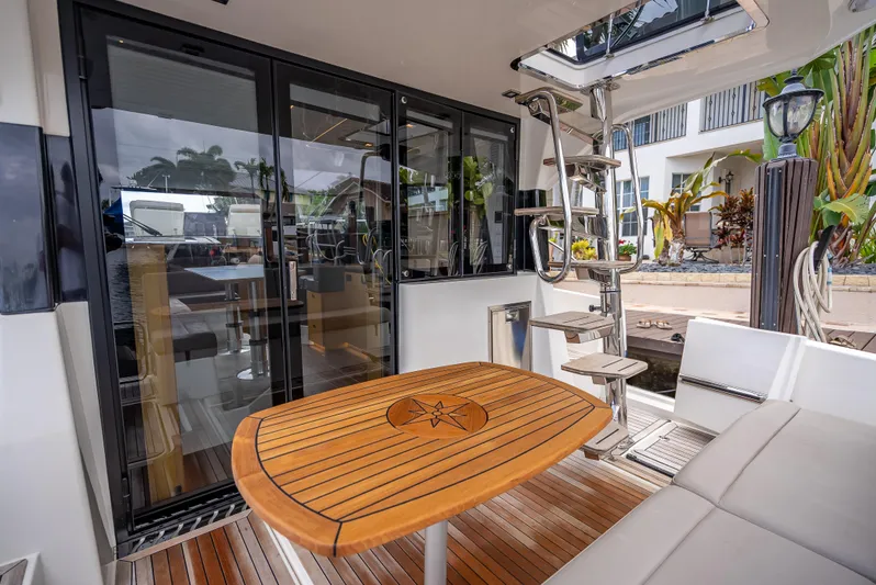  Yacht Photos Pics 2021 Skamander Monaco yacht interior with wooden table, glass doors, and spiral staircase.