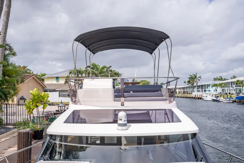  Yacht Photos Pics 2021 Skamander Monaco yacht with canopy, docked by a canal under cloudy skies.