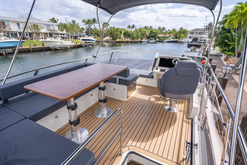  Yacht Photos Pics Luxurious 2021 Skamander Monaco yacht deck with seating and helm, overlooking a serene waterfront.