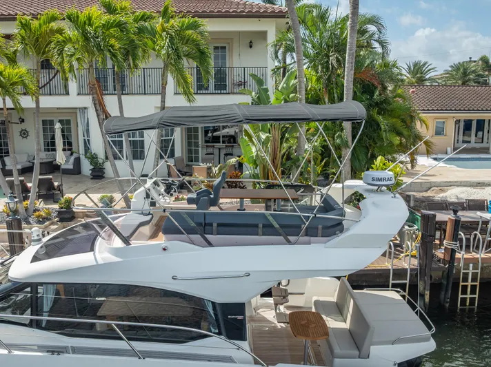  Yacht Photos Pics 2021 Skamander Monaco yacht docked near a luxurious waterfront home with palm trees.