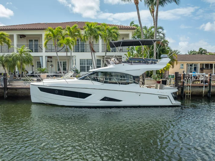  Yacht Photos Pics 2021 Skamander Monaco yacht docked by a waterfront villa with palm trees.