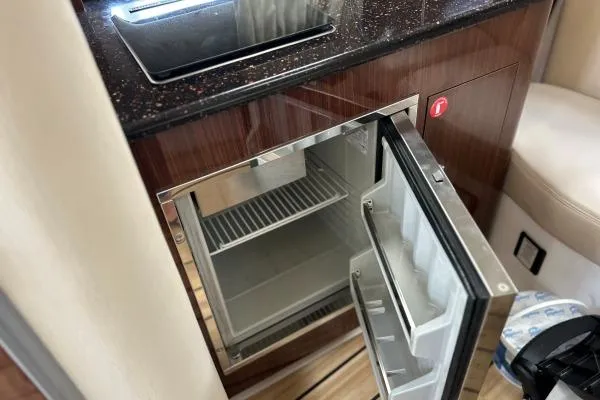 Qtech-1 Yacht Photos Pics 2015 Regal 32 Express yacht interior with open mini fridge and sleek countertop.