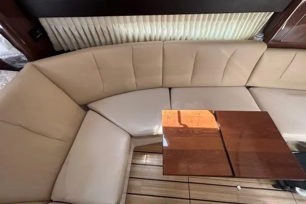 Qtech-1 Yacht Photos Pics 2015 Regal 32 Express interior with beige seating and wooden table.