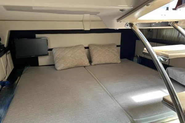 Qtech-1 Yacht Photos Pics 2015 Regal 32 Express cabin interior with cozy bedding and a small TV.