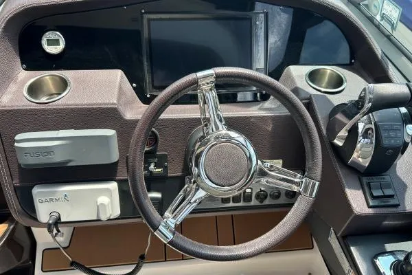 Qtech-1 Yacht Photos Pics Steering wheel and dashboard of a 2015 Regal 32 Express boat with navigation controls.