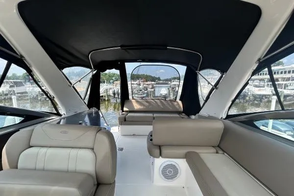 Qtech-1 Yacht Photos Pics 2015 Regal 32 Express boat interior with beige seating and black canopy at marina.