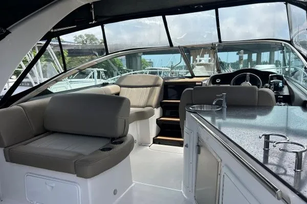 Qtech-1 Yacht Photos Pics Interior of 2015 Regal 32 Express boat with seating and kitchenette.