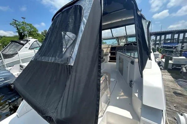 Qtech-1 Yacht Photos Pics 2015 Regal 32 Express boat with black canopy docked at marina.