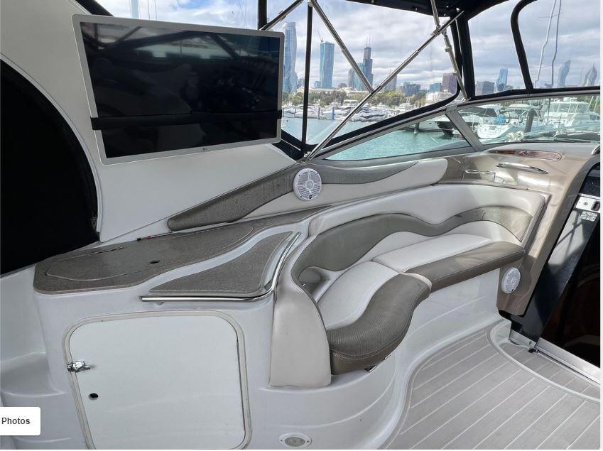 Interior of a 2004 Larson 370 boat with seating and a mounted TV.