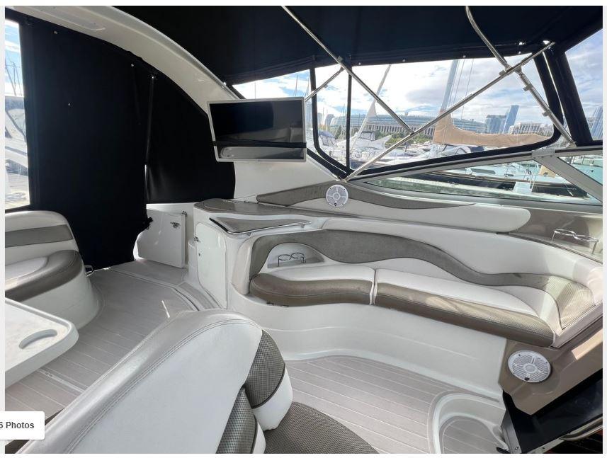 Interior of a 2004 Larson 370 boat with seating and a mounted TV.