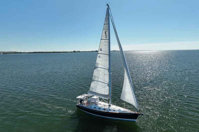 Munequita Yacht Photos Pics Sailing yacht Tartan 4000, 2013 model, gliding on open water under clear skies.