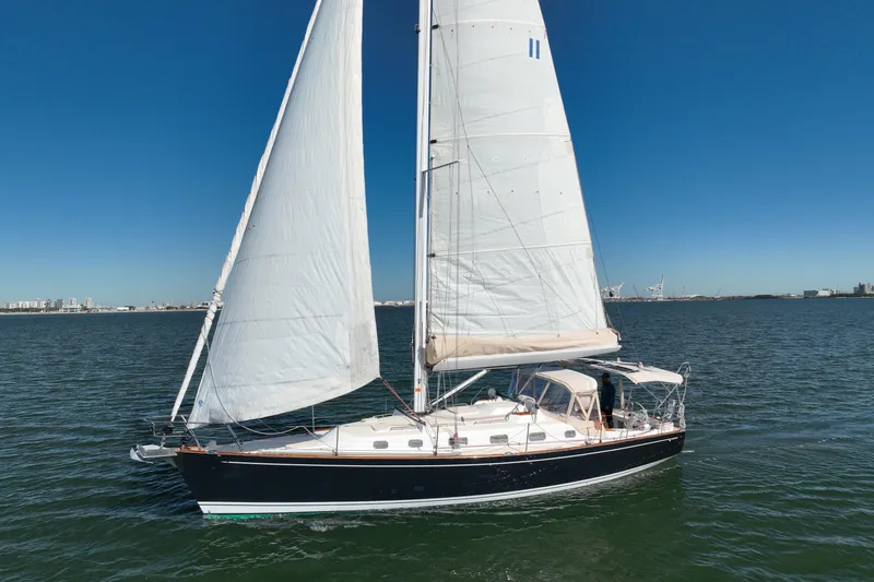 Munequita Yacht Photos Pics Sailing yacht Tartan 4000, 2013 model, cruising on open water under clear blue skies.