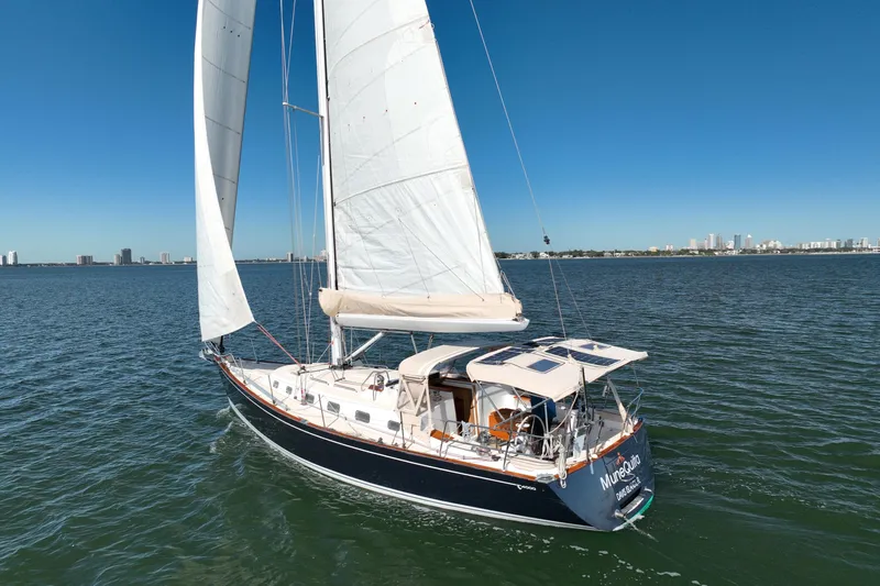 Munequita Yacht Photos Pics Sailing yacht Tartan 4000, 2013 model, cruising on open water under clear blue skies.