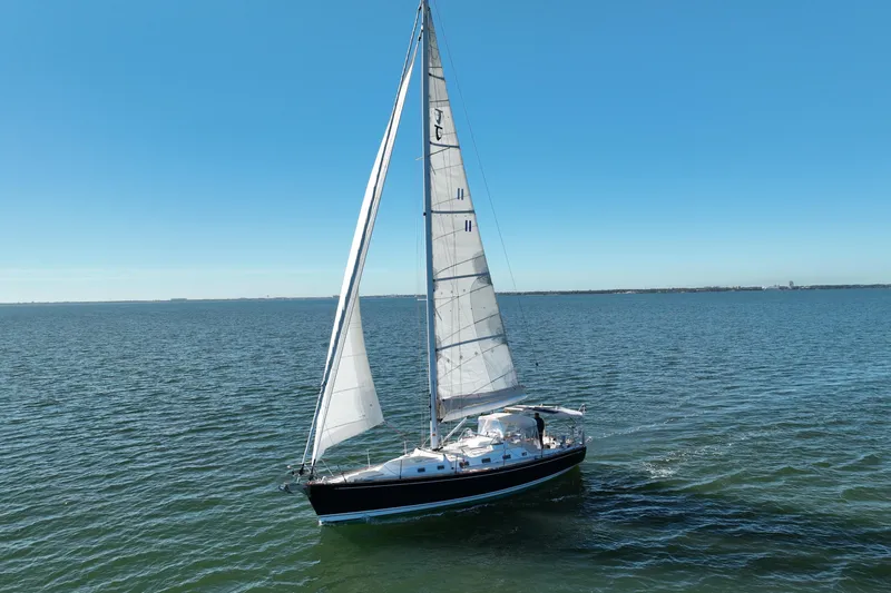 Munequita Yacht Photos Pics Sailing yacht Tartan 4000, 2013 model, gliding on open sea under clear blue sky.