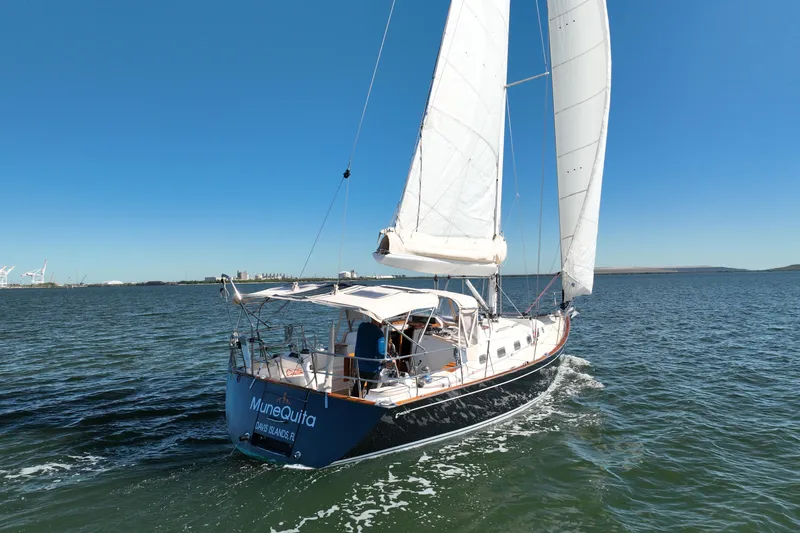 Munequita Yacht Photos Pics Sailing yacht Tartan 4000, 2013 model, cruising on open water under clear blue skies.