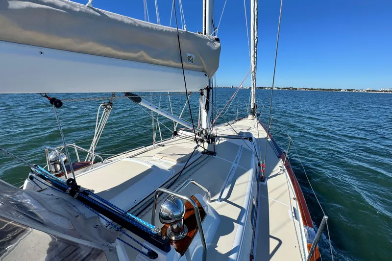 Munequita Yacht Photos Pics Sailing yacht Tartan 4000, 2013 model, cruising on calm blue waters under clear skies.