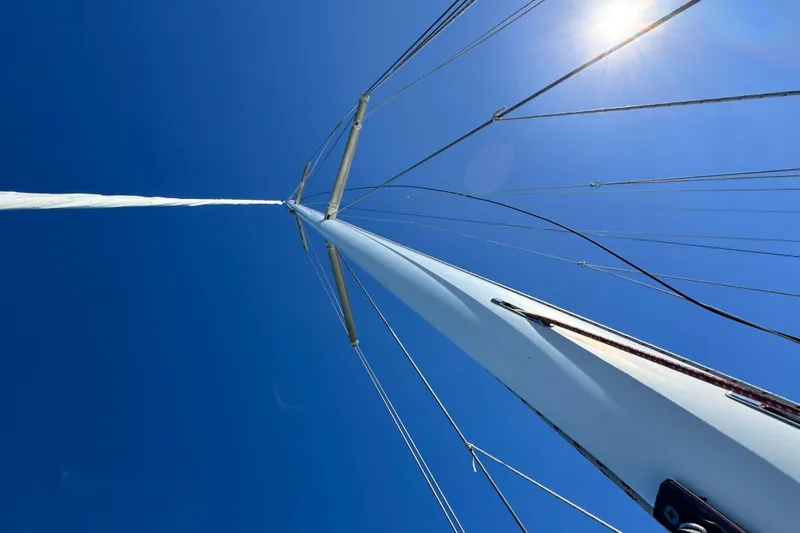 Munequita Yacht Photos Pics Looking up at the mast of a 2013 Tartan 4000 sailboat against a clear blue sky.