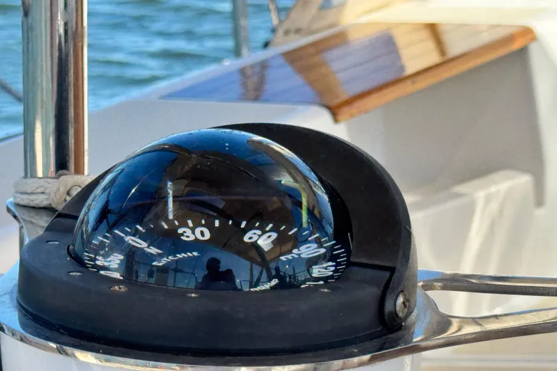 Munequita Yacht Photos Pics Compass on Tartan 4000 sailboat, 2013 model, reflecting blue sky and water.