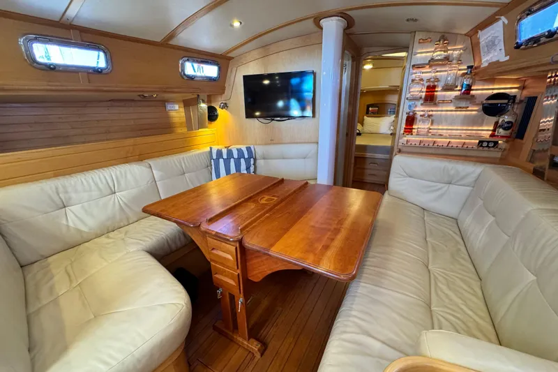 Munequita Yacht Photos Pics Luxurious interior of 2013 Tartan 4000 yacht with wooden table and leather seating.