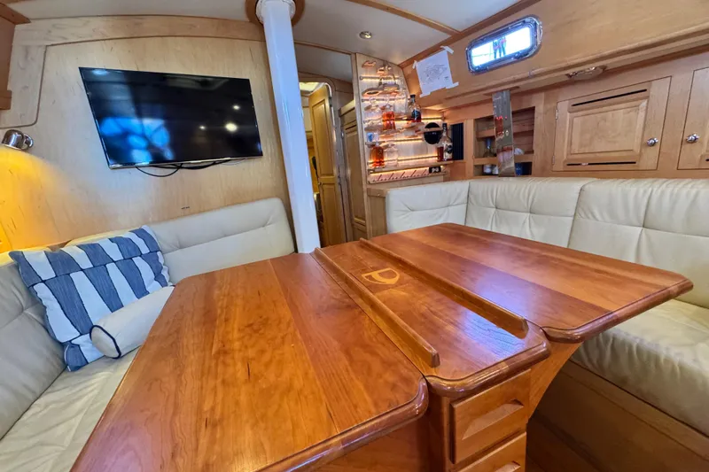 Munequita Yacht Photos Pics Luxurious interior of 2013 Tartan 4000 yacht with wooden table and plush seating.