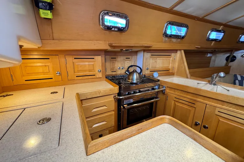 Munequita Yacht Photos Pics Wooden yacht kitchen interior with stove, sink, and cabinets in a 2013 Tartan 4000.
