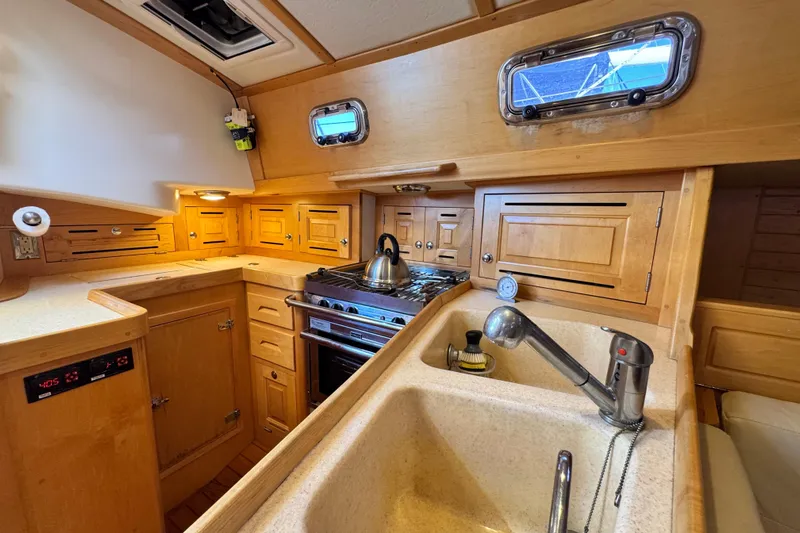 Munequita Yacht Photos Pics Cozy Tartan 4000 yacht kitchen with wooden cabinets, stove, and sink, 2013 model.
