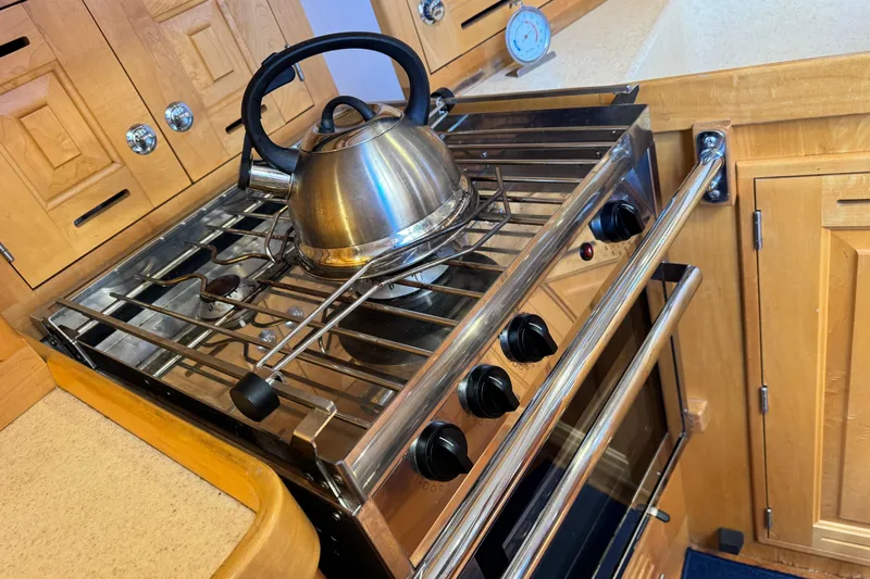Munequita Yacht Photos Pics Stainless steel stove with kettle in wooden kitchen, Tartan 4000, 2013 model.