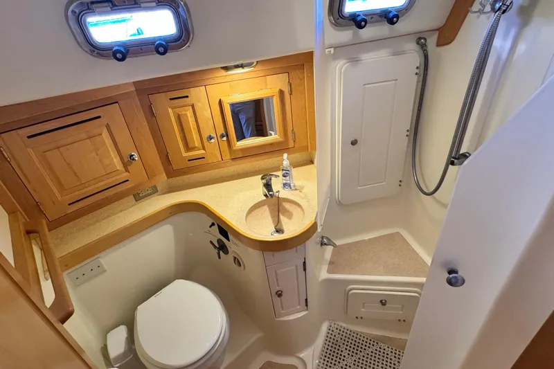 Munequita Yacht Photos Pics 2013 Tartan 4000 yacht bathroom with wooden cabinets, sink, and shower area.