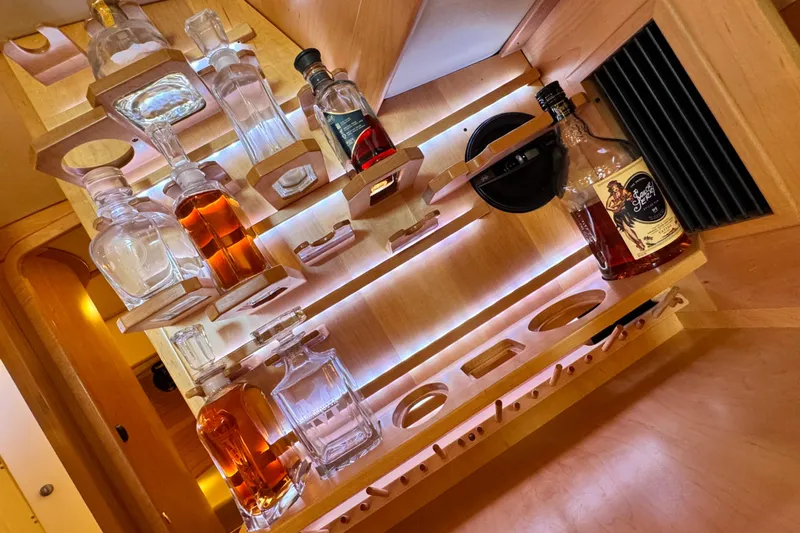 Munequita Yacht Photos Pics Luxurious wooden bar setup in a 2013 Tartan 4000 yacht, featuring various liquor bottles.