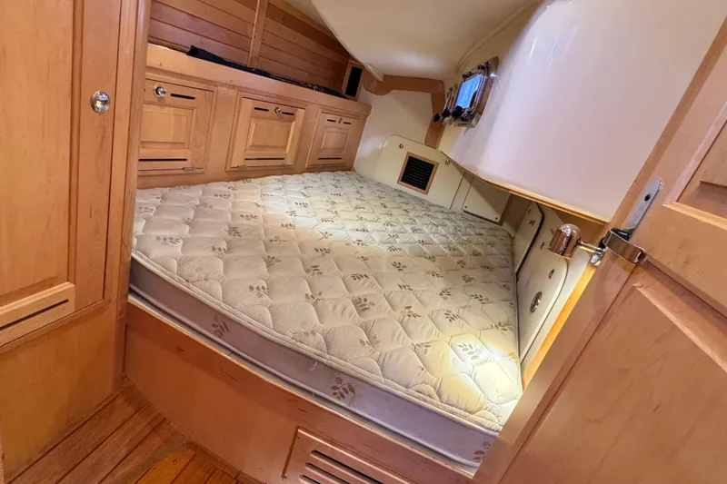 Munequita Yacht Photos Pics Cozy cabin interior of 2013 Tartan 4000 sailboat with wooden cabinetry and comfortable mattress.