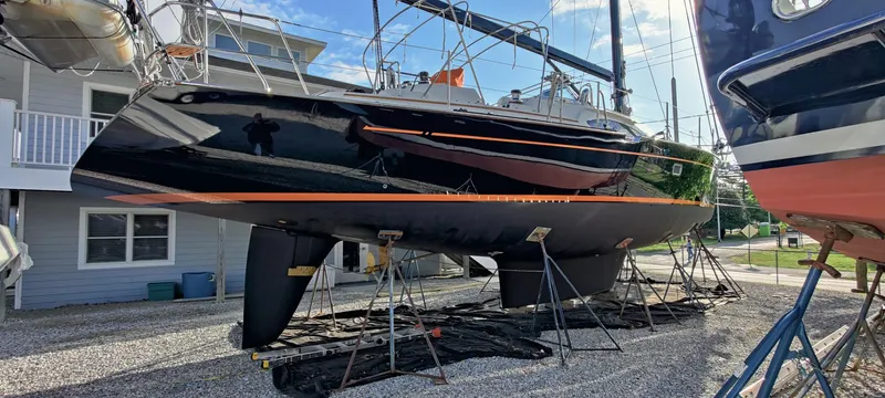 Solitude Yacht Photos Pics Sleek black Passport 545 sailboat from 2018 on dry dock, supported by stands.