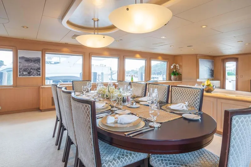 Chanson Yacht Photos Pics Luxurious dining area on a 1995 Christensen Tri-Deck yacht, elegantly set table with panoramic views.