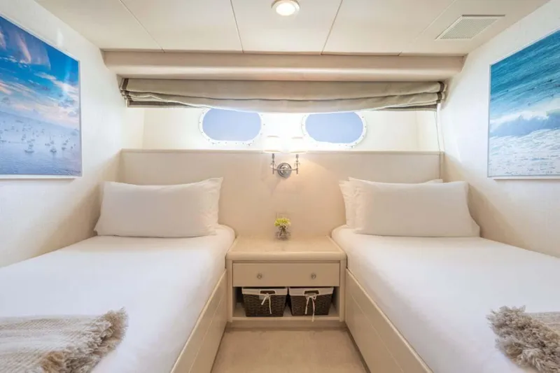 Chanson Yacht Photos Pics Luxurious twin cabin on 1995 Christensen Tri-Deck yacht, featuring elegant decor and ocean-themed artwork.