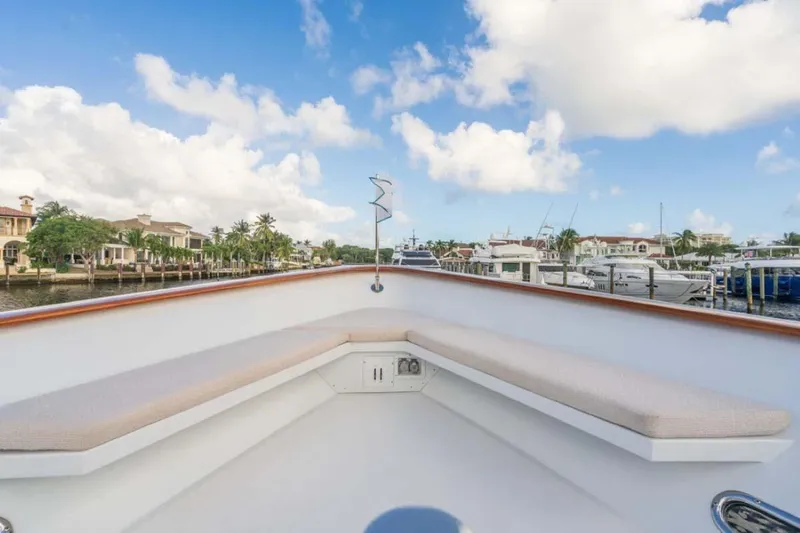 Chanson Yacht Photos Pics Christensen Tri-Deck 1995 yacht deck with seating, docked in a marina under blue skies.
