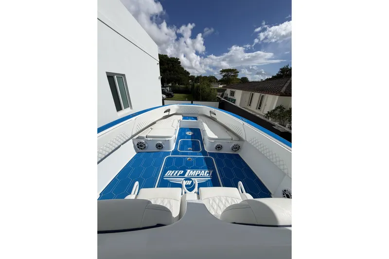  Yacht Photos Pics 2012 Deep Impact 399 Sport boat with blue deck and white seating under a clear sky.