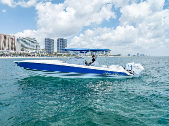 Yacht Photos Pics 2025 Nor-Tech 340 Sport boat cruising near a city skyline on a sunny day.