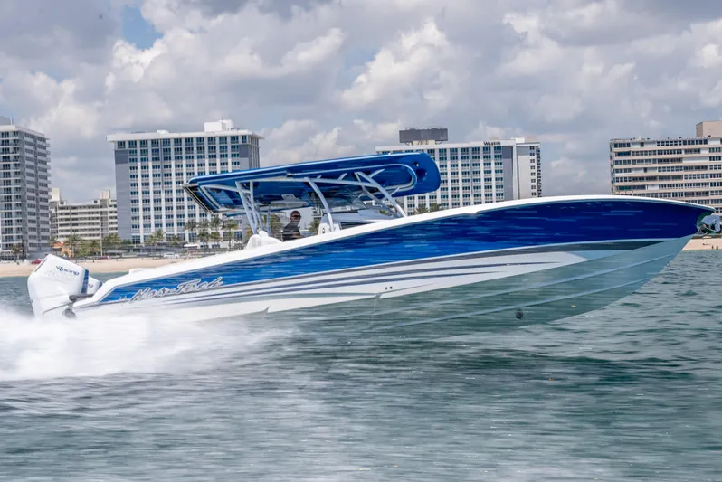  Yacht Photos Pics 2025 Nor-Tech 340 Sport boat cruising on water, with city skyline in background.