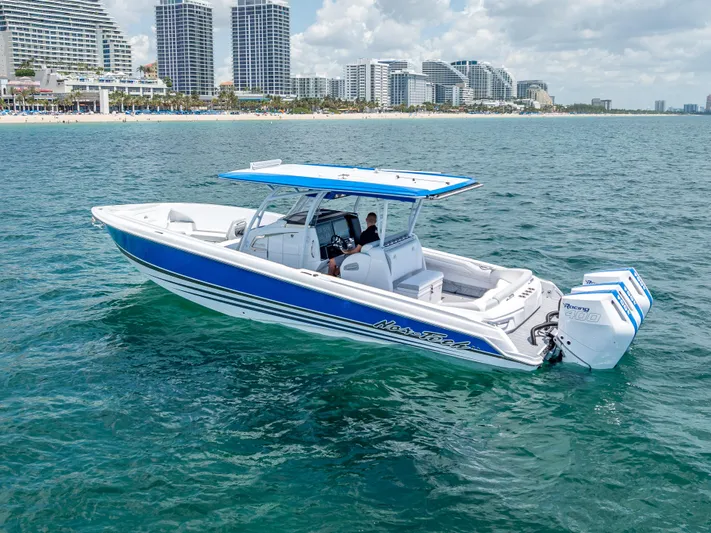  Yacht Photos Pics 2025 Nor-Tech 340 Sport boat cruising near a city skyline on a sunny day.