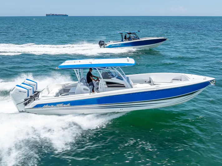  Yacht Photos Pics 2025 Nor-Tech 340 Sport boat cruising on ocean, featuring sleek blue and white design.